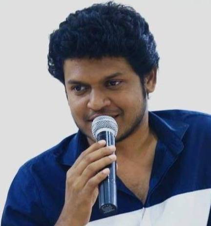 Mr. Praveen speaking into a microphone